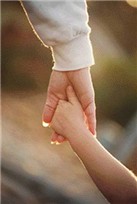 En vuxen hand som hller i ett barns hand.